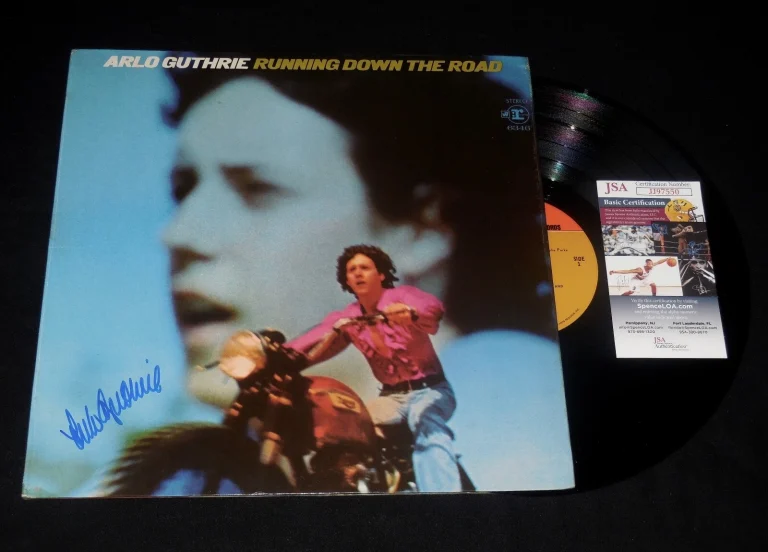 ARLO GUTHRIE AUTOGRAPHED VINYL RECORD ALBUM (RUNNING DOWN THE ROAD) - JSA COA!